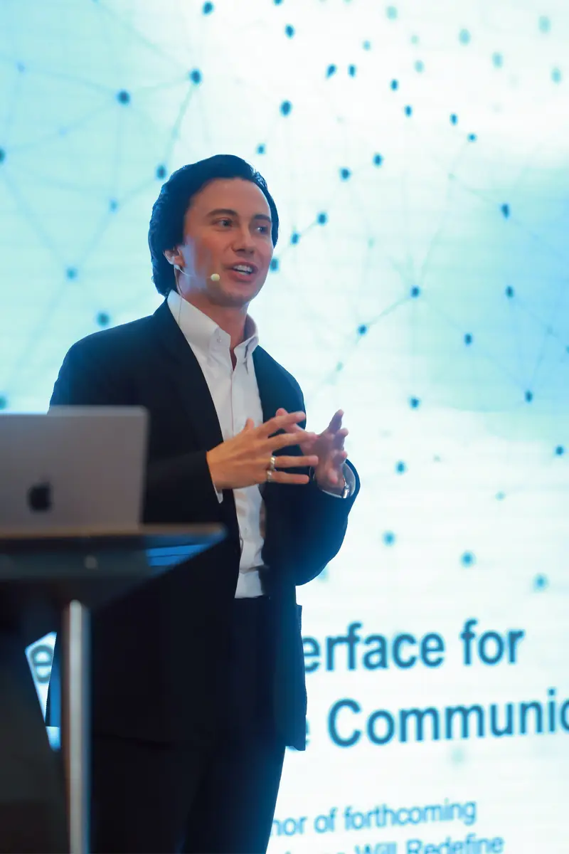 Close-up of Velco Dar speaking on stage at the AI+Q Summit Tour